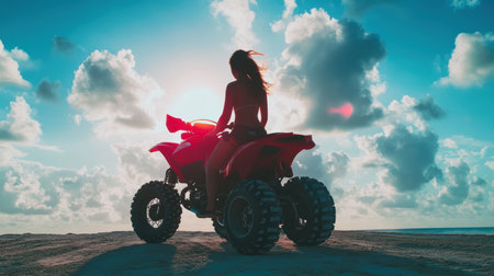 Arafed woman rides a four-wheeler on a sandy beach, enjoying the sun and sea breeze.の素材