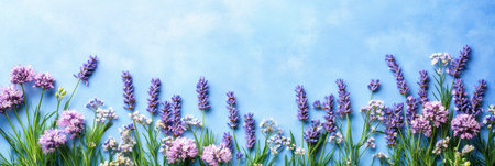 Lavender flowers bloom vividly against a serene blue sky backdrop,.の素材