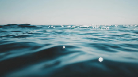 A bright light reflects on a serene blue ocean surface,.の素材