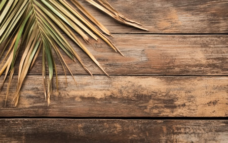 A detailed view of a palm leaf resting on a rustic wooden surface.,の素材