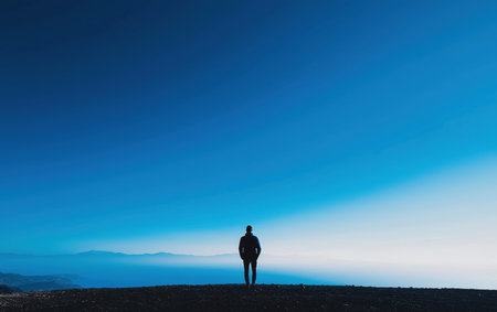 A person stands atop a mountain, gazing at the vast ocean below.,の素材