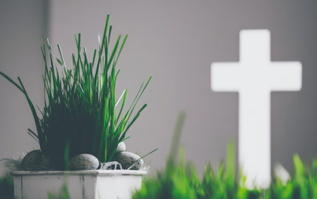 A white cross stands surrounded by fresh grass in a decorative pot.,の素材