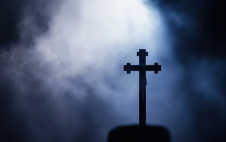 A solitary cross stands on a hill under a dramatic cloudy sky, symbolizing Easter's significance.,の素材