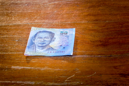 Bill 50 bath of thailand on wood floor
