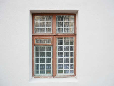 Dirty wooden window with metal grid. Wall of house, vintage grunge exterior