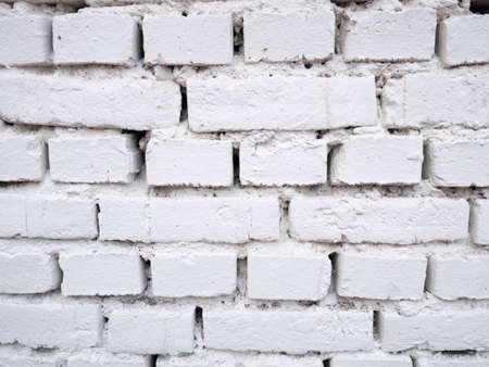White brick wall background design. Building surface texture. Old cracked construction, stone wallpaper.の写真素材