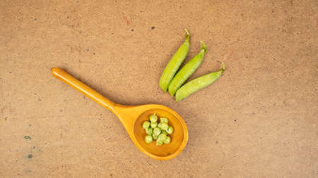 Green peas in a spoon on a grunge background. Vegetarian ripe food, natural harvest.の写真素材
