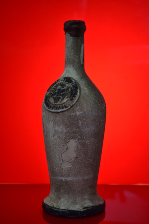 Old wine bottle on a red backgroundの写真素材