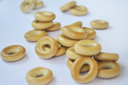 Small heap of golden bagels isolated on whiteの写真素材