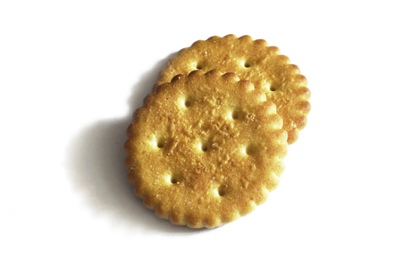Classic round golden yellow salted cracker isolated on over white backgroundの写真素材