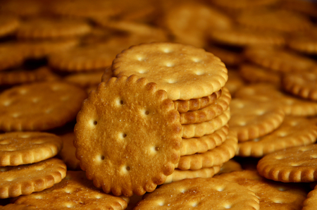 Closeup of salted crackers. Background image of classic salty cracker on a brown wooden table
