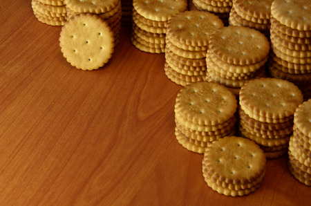 Background image of classic salty cracker on a brown wooden table with copyspaceの写真素材