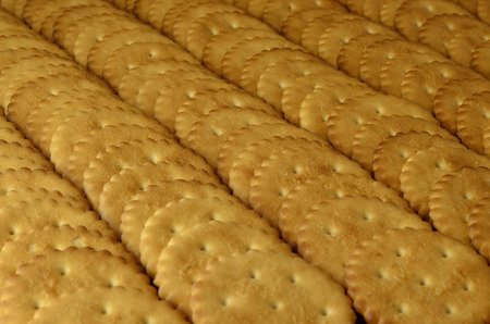 Closeup of salted crackers. Background image of classic salty cracker on a brown wooden table