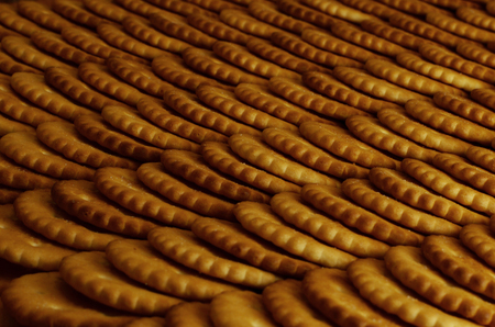 Closeup of salted crackers. Background image of classic salty cracker on a brown wooden table