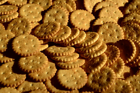 Closeup of salted crackers. Background image of classic salty cracker on a brown wooden table