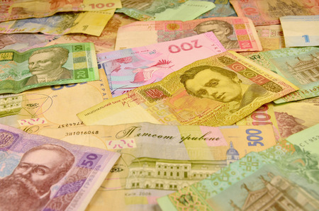 Background image of many Ukrainian banknotes of different colors and size. Conceptual image for the Ukrainian banking operations, withdraw funds, wealth and possession of huge sums of money in Ukraineの写真素材