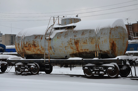 Detailed photo of snowy frozen railway freight car. A fragment of the component parts of the freight car on the railroad in snowy winter eveningの写真素材