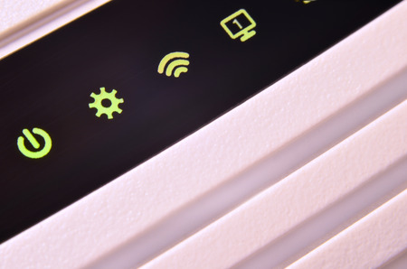 Detailed photo light bulbs from the Internet modem. Abstract technology background. Modern glowing lights on the surface of white plastic wi-fi routerの写真素材