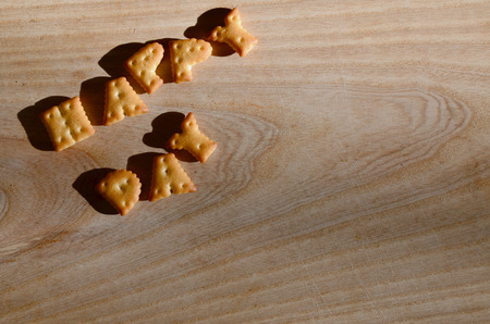 Happy day. Text from the salty crackers as printed English letters that lie on a wooden chopping board. Message, lined with edible lettersの写真素材