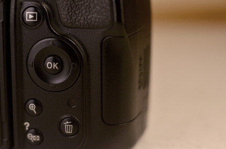 Close-up macro shot of a modern digital SLR camera. Detailed photo of black camera body with buttons...