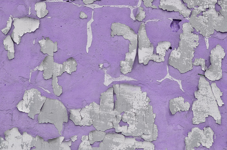 Close-up weathered and stained violet obsolete concrete wall texture. Old detailed surface with cracked paint layerの写真素材