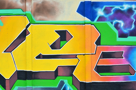 Multicolored graffiti on an old concrete wall. A beautiful form of vandalism in urban conditions....