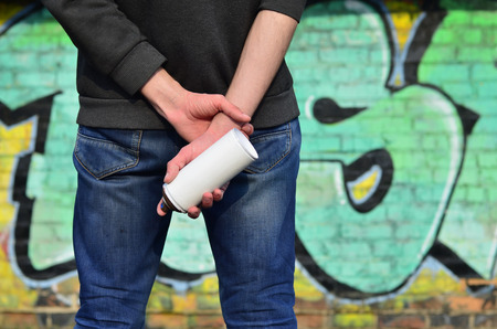A photo of a street artist who draws a new colored picture on a brick wall. One of the types of street art is the youth graffiti culture. Decoration of walls of old and abandoned buildingsの写真素材