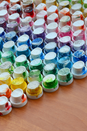 A pattern from a many nozzles from a paint sprayer for drawing graffiti, smeared into different colors. The plastic caps are arranged in many rows forming the color of the rainbowの写真素材