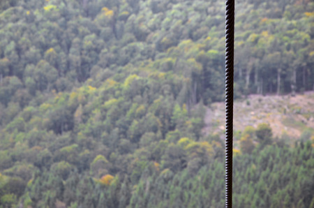 Iron cable from the transportation system of the funicular on the background of a green mountain forestの写真素材