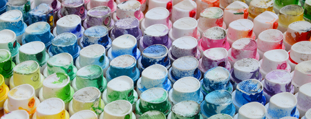 A pattern from a many nozzles from a paint sprayer for drawing graffiti, smeared into different colors. The plastic caps are arranged in many rows forming the color of the rainbowの写真素材