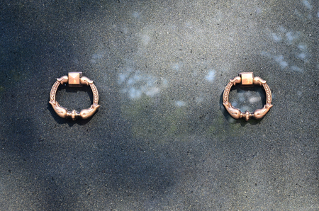 The front part of the granite crypt with metal ring handles in the cemetery
