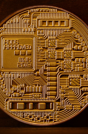One new golden physical bitcoin is lies on dark wooden backgound, close up. High resolution photo. Cryptocurrency mining conceptの写真素材