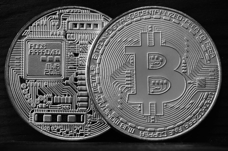 Two new silver physical bitcoins lies on dark wooden backgound, close up. High resolution photo. Cryptocurrency mining conceptの写真素材