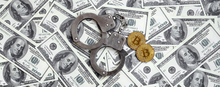Police handcuffs and bitcoins lie on a large number of dollar bills. The concept of problems with the law during the illegal cryptocurrency mining and bitcoin operationsの写真素材