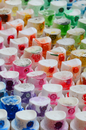 A pattern from a many nozzles from a paint sprayer for drawing graffiti, smeared into different colors. The plastic caps are arranged in many rows forming the color of the rainbowの写真素材