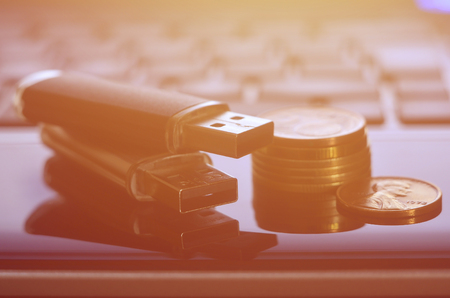 USB flash cards lying on black laptop case in front of his keyboard. The concept of earning on the...