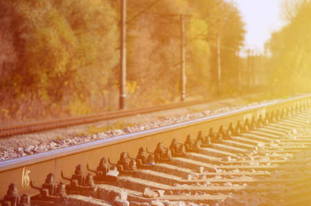 Autumn industrial landscape. Railway receding into the distance among green and yellow autumn treesの写真素材
