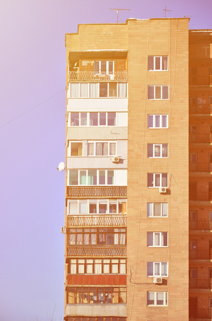 Detailed photo of multi-storey residential building with lots of balconies and windows. Hostels for poor people in Russia and Ukraine in a damaged conditionのeditorial素材