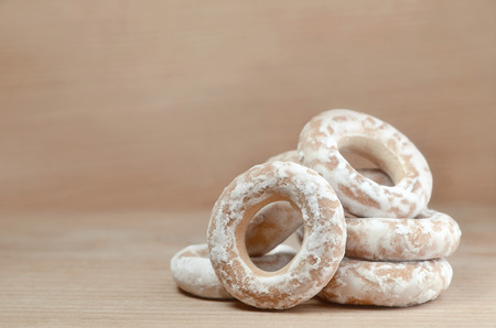 Still life of donut glaze on a wooden surface. Glazed bagels are a small bunch on a wooden table. Flour sweets to the Tea Partyの写真素材
