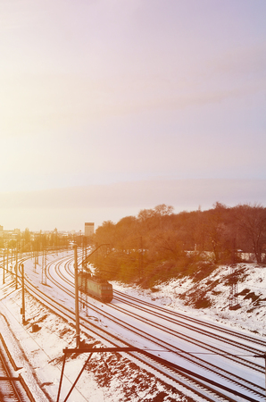 Winter landscape with a railway train on a railway surrounded by a city panorama with lots of houses and buildings against a cloudy sky backgroundの写真素材