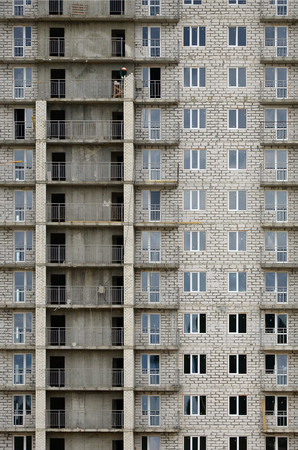 Textured pattern of a russian whitestone residential house building wall with many windows and balcony under constructionのeditorial素材