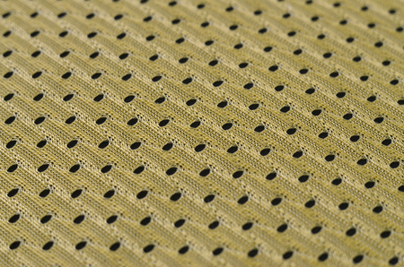 Background image of a fabric texture of a yellow jersey made of polyester nylon. Macro photo with shallow depth of fieldの写真素材