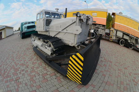 Photo of a gray bulldozer among the railway trains. Strong distortion from the fisheye lensのeditorial素材