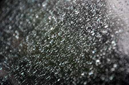 Background image of rain drops on a glass window. Macro photo with shallow depth of fieldの写真素材