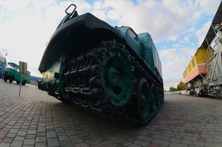 Photo of a Russian green armored car on a caterpillar track among the railway trains. Strong distortion from the fisheye lensのeditorial素材