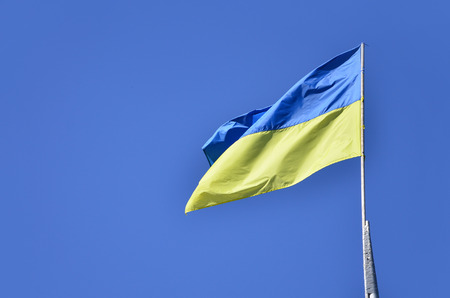 Ukrainian flag against the blue cloudless sky. The official flag of the Ukrainian state includes yellow and blue colorsの写真素材