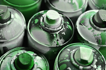 A lot of used spray cans of paint close-up. Dirty and smeared cans for drawing graffiti. The concept of a sweeping and careless drawing of paint. Creative art imageの写真素材