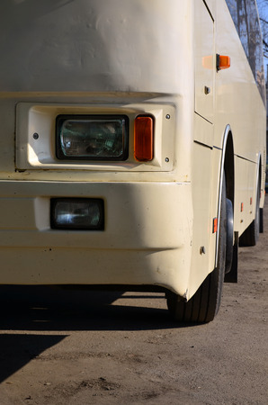 Photo of the hull of a large and long yellow bus. Close-up front view of a passenger vehicle for transportation and tourismの写真素材