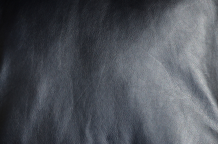 Texture of black leather or dermantin with folds, used as material for women's and men's bags, suitcases, pillows for office sofas and also for upholstered furnitureの写真素材