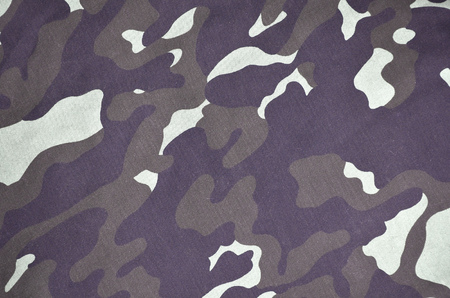 Texture of fabric with a camouflage painted in colors of the marsh. Army background image. Textile pattern of military camouflage fabricの写真素材